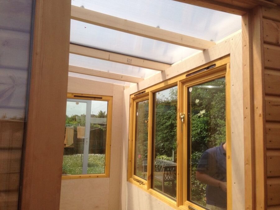 Inside a timber home office with windows and clear roof panels