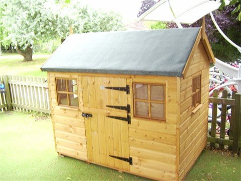 Timber wendy house with a green roof and stable door